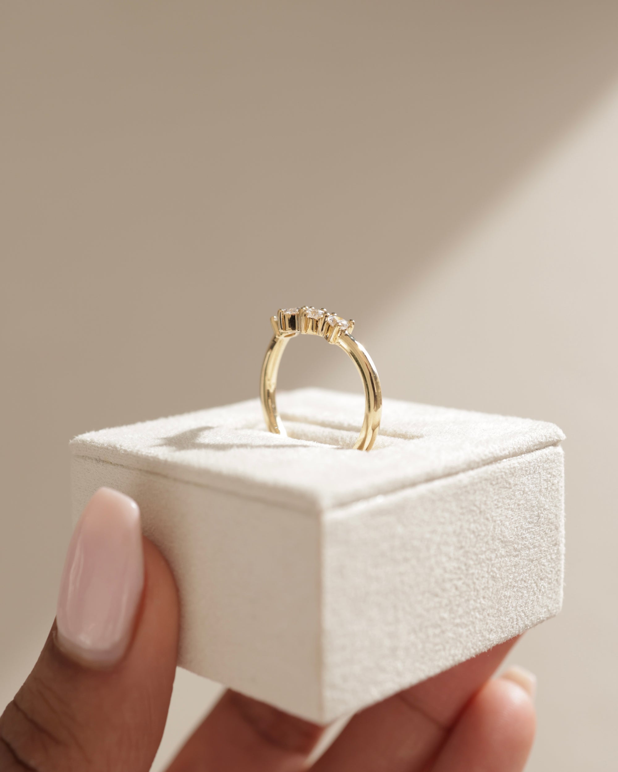 0.48 TCW trillion cut moissanite curved wedding band – unique and modern contour design in polished gold, perfect for stacking with engagement rings or wearing solo.