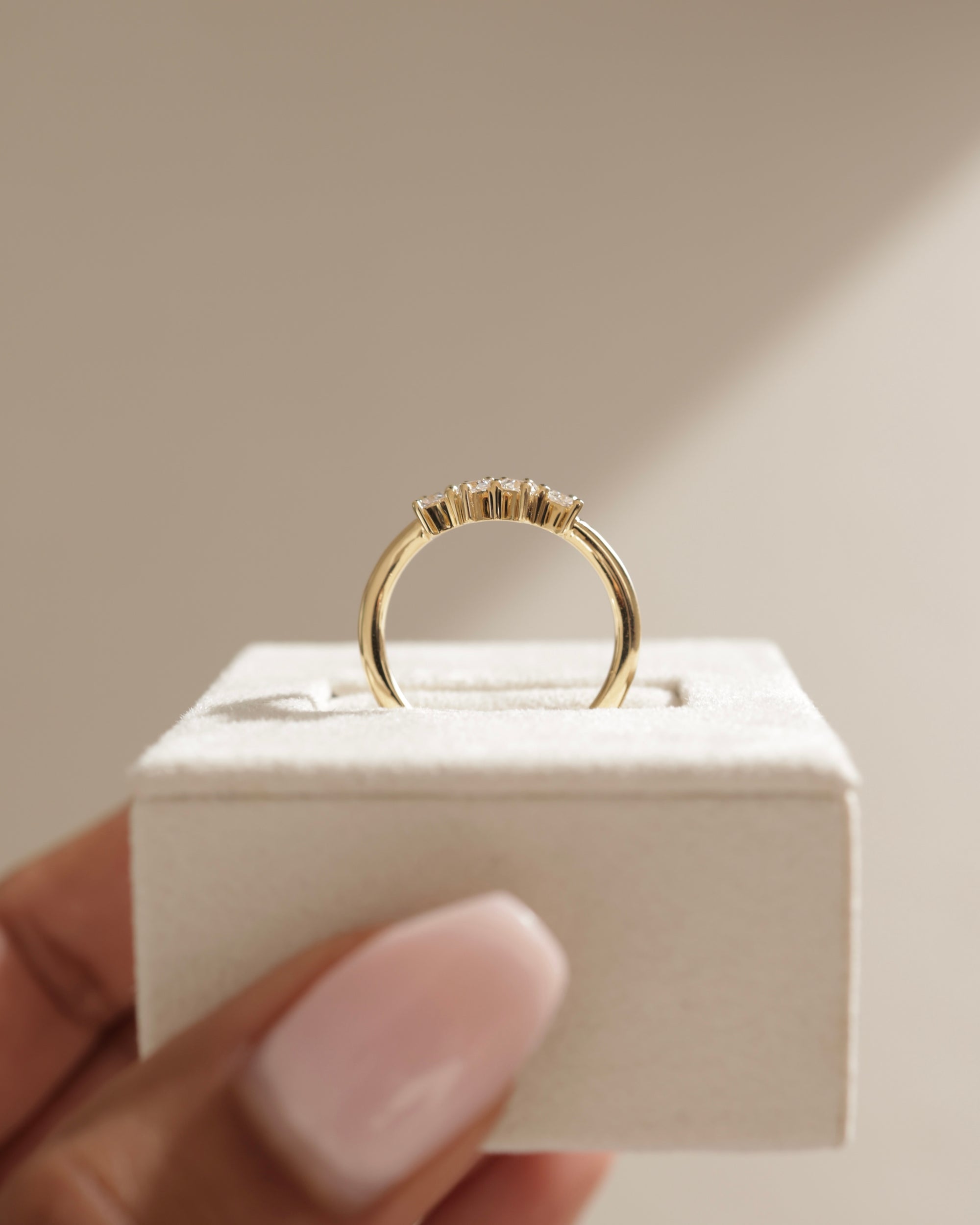 0.48 TCW trillion cut moissanite curved wedding band – unique and modern contour design in polished gold, perfect for stacking with engagement rings or wearing solo.