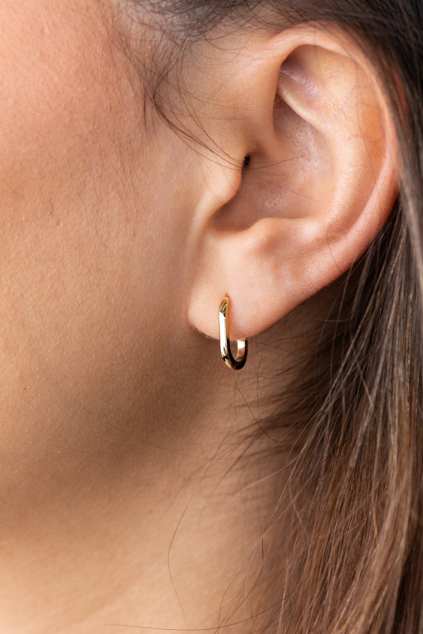 Plain elongated oval hoop earrings with a smooth polished finish – modern and minimalist gold design, perfect for everyday wear or elegant layering.