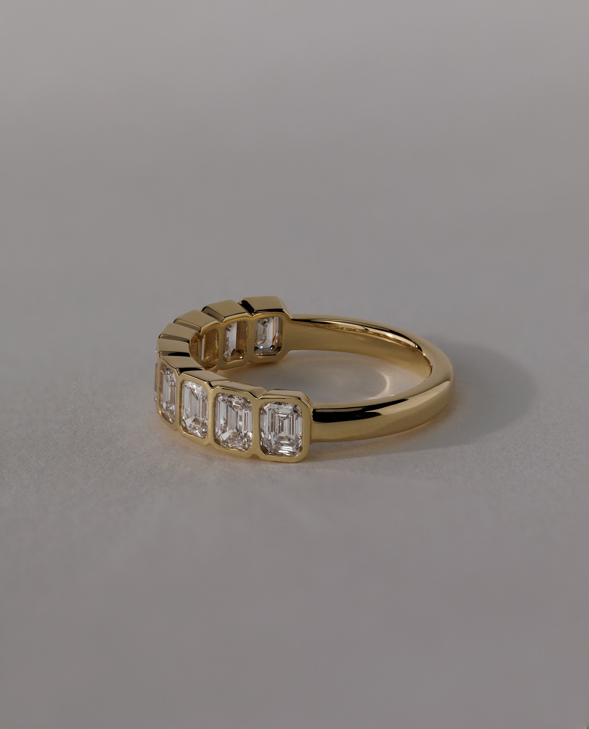 2.25 TCW emerald cut moissanite wedding band with bezel setting – modern and secure gold band featuring step-cut stones, perfect for bold bridal or statement wear.