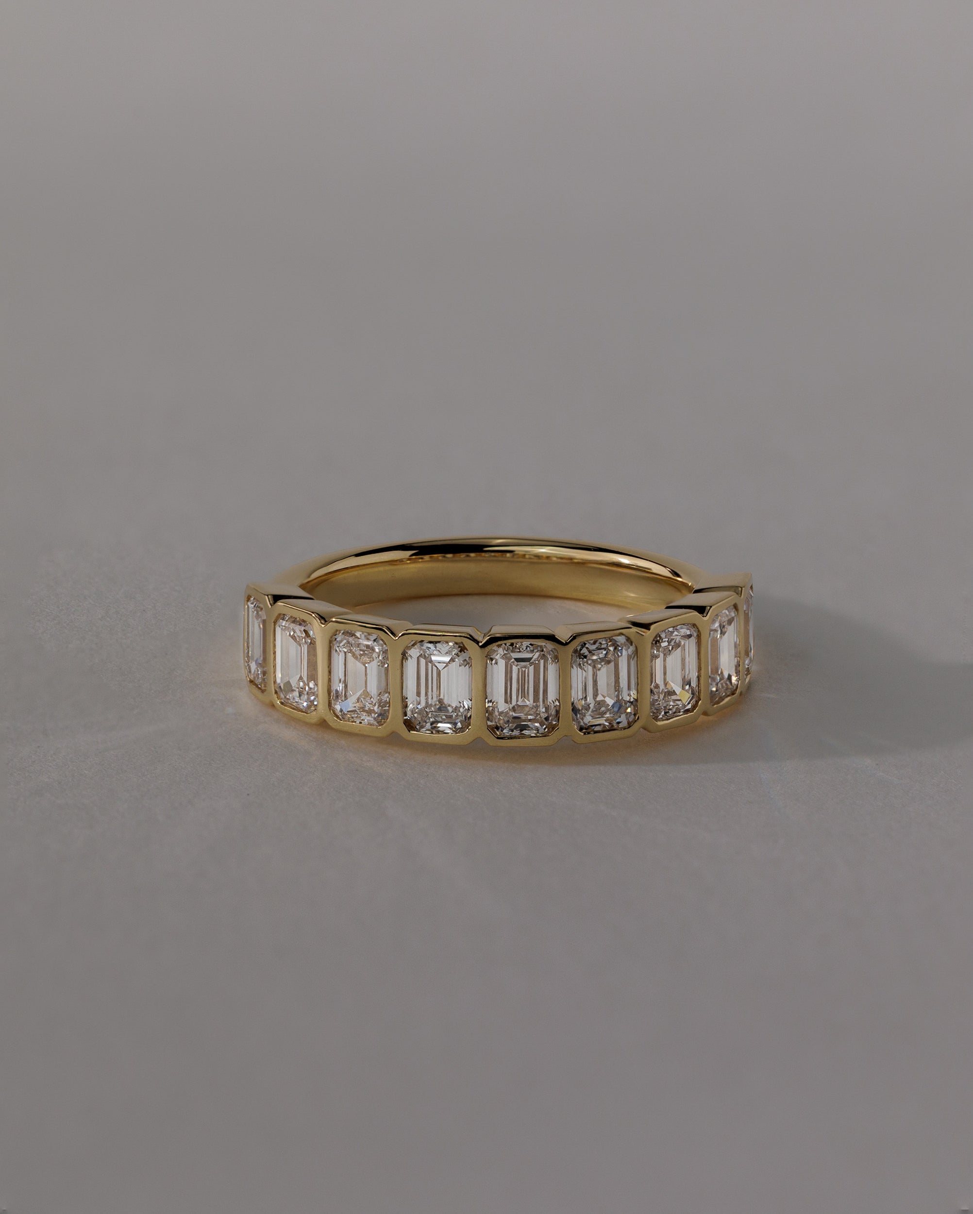 2.25 TCW emerald cut moissanite wedding band with bezel setting – modern and secure gold band featuring step-cut stones, perfect for bold bridal or statement wear.