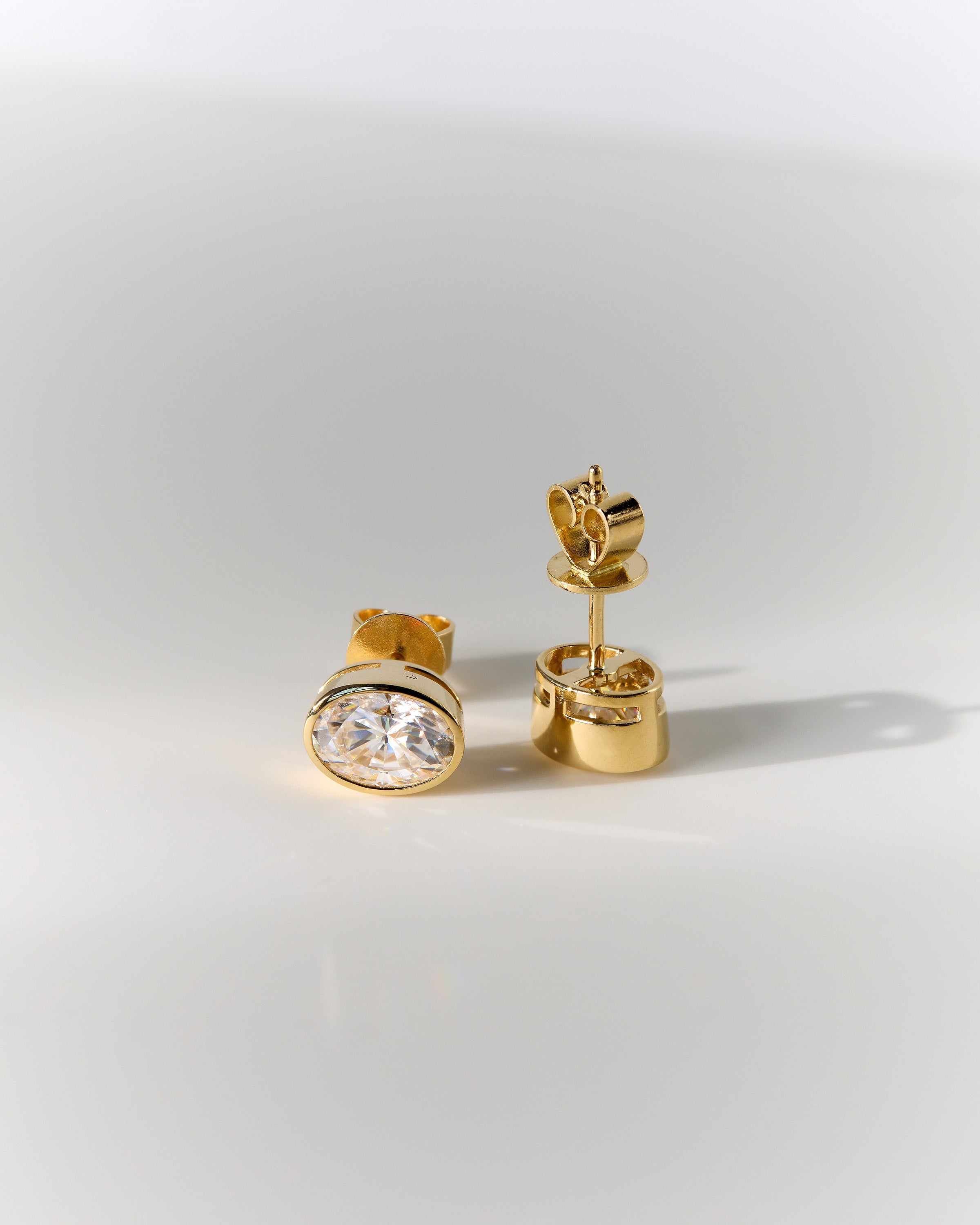 1.00 CT oval cut moissanite bezel set earrings – sleek and elegant gold studs with a modern, secure setting, perfect for everyday wear or special occasions.