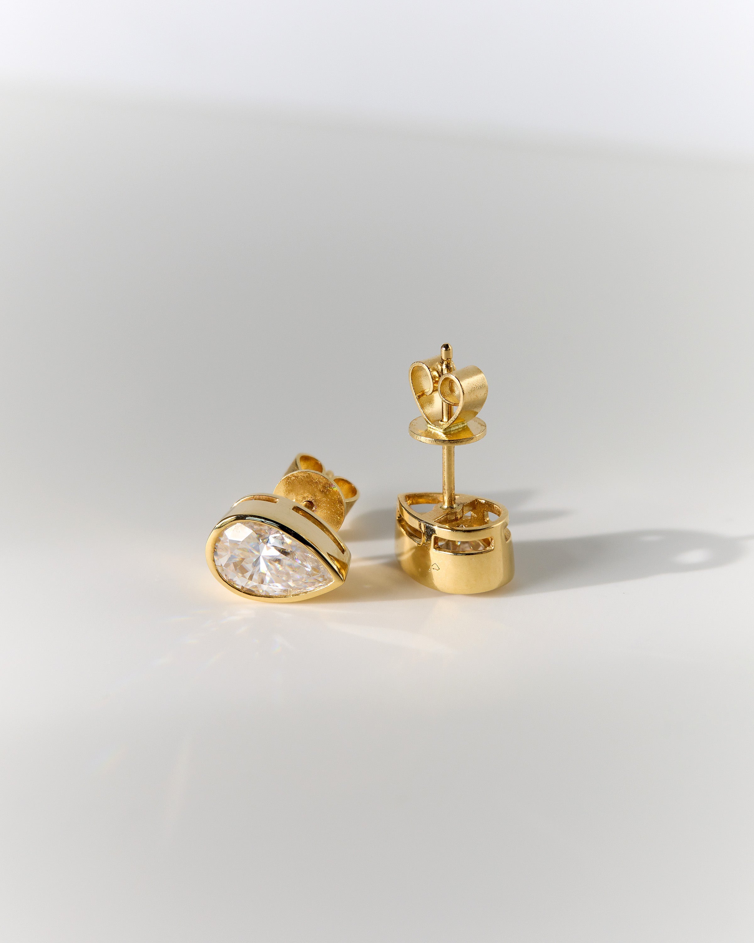 2.00 CT pear cut moissanite bezel set earrings – elegant and secure gold studs with a modern twist, perfect for bridal sparkle or everyday luxury.