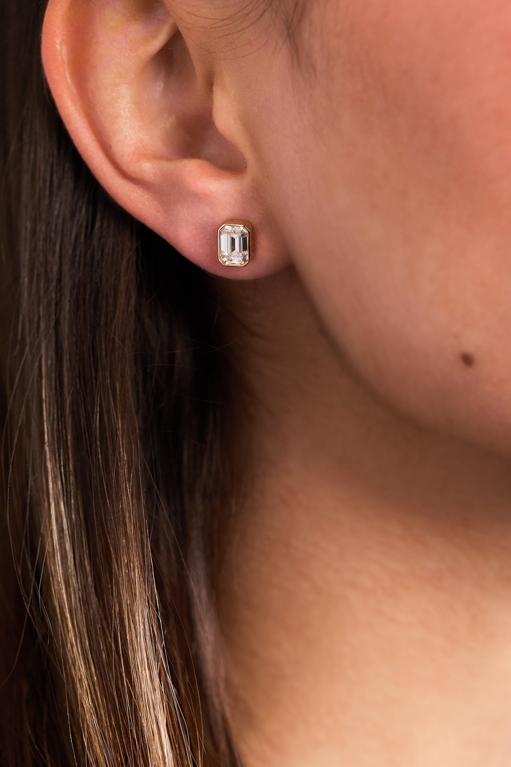 2.00 TCW emerald cut moissanite bezel set earrings – sleek and sophisticated gold studs featuring step-cut stones, perfect for modern bridal or everyday luxury.