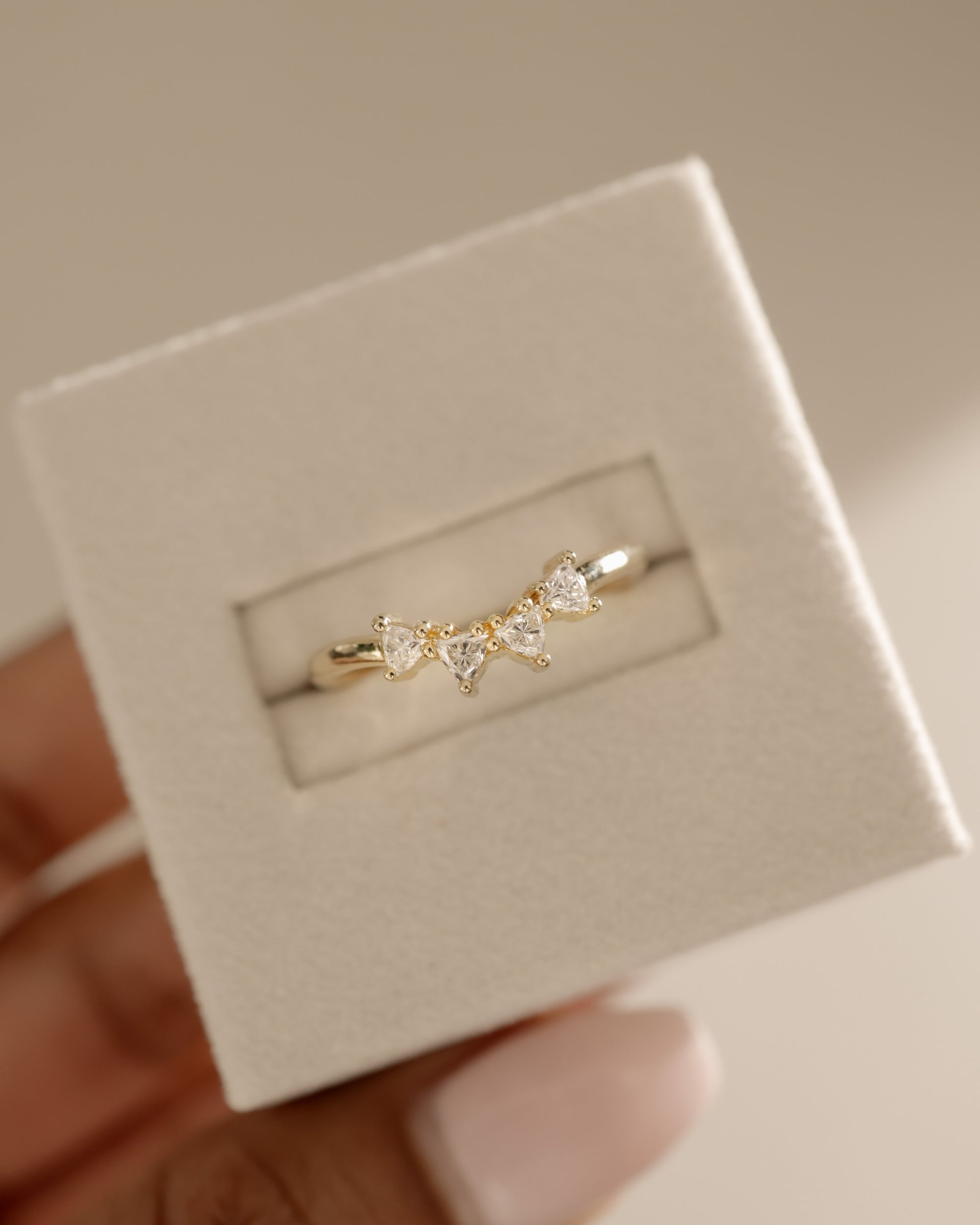 0.48 TCW trillion cut moissanite curved wedding band – unique and modern contour design in polished gold, perfect for stacking with engagement rings or wearing solo.