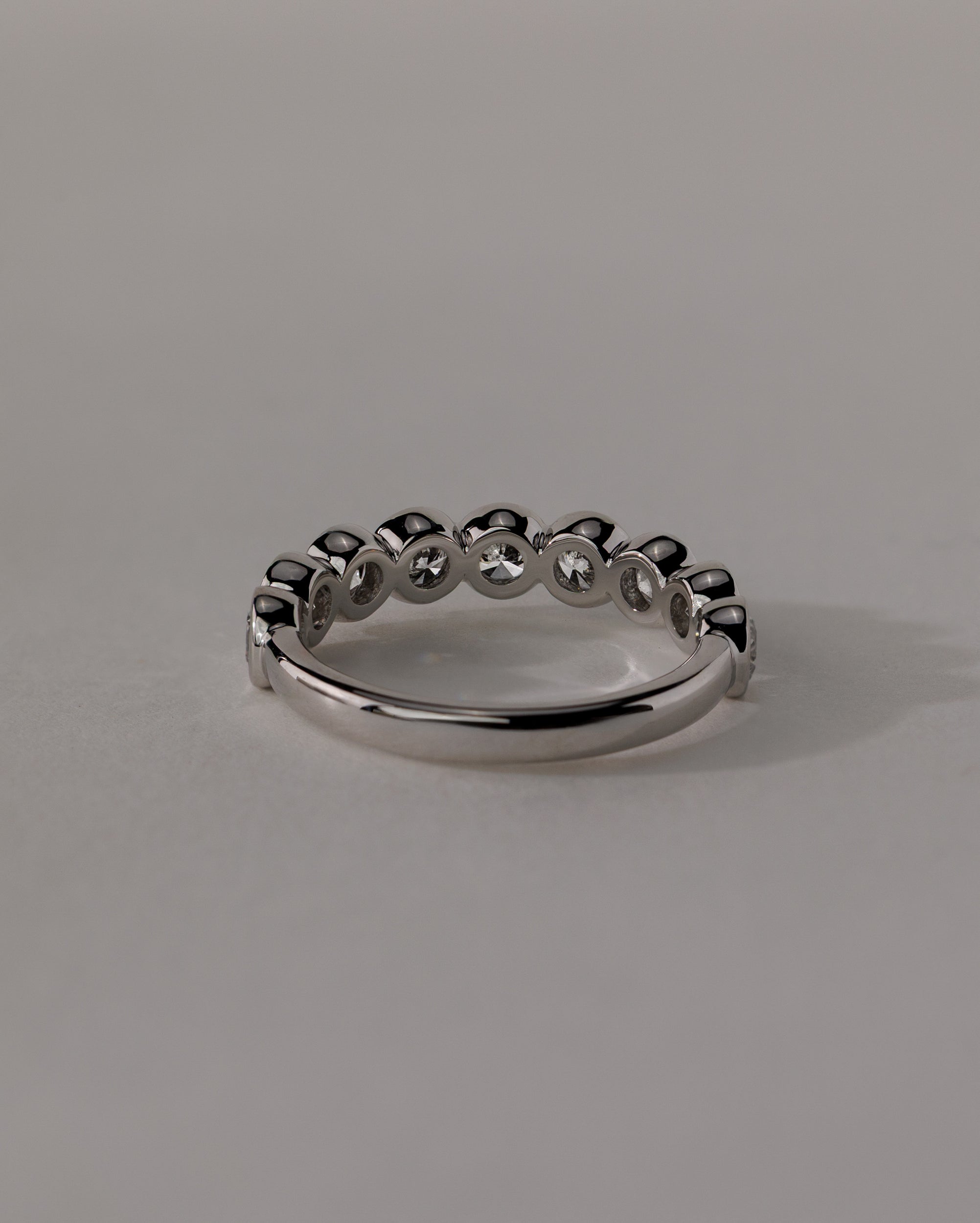 0.40 TCW round cut moissanite wedding band with bezel setting – minimalist and elegant gold band offering secure sparkle, ideal for bridal stacking or everyday wear.