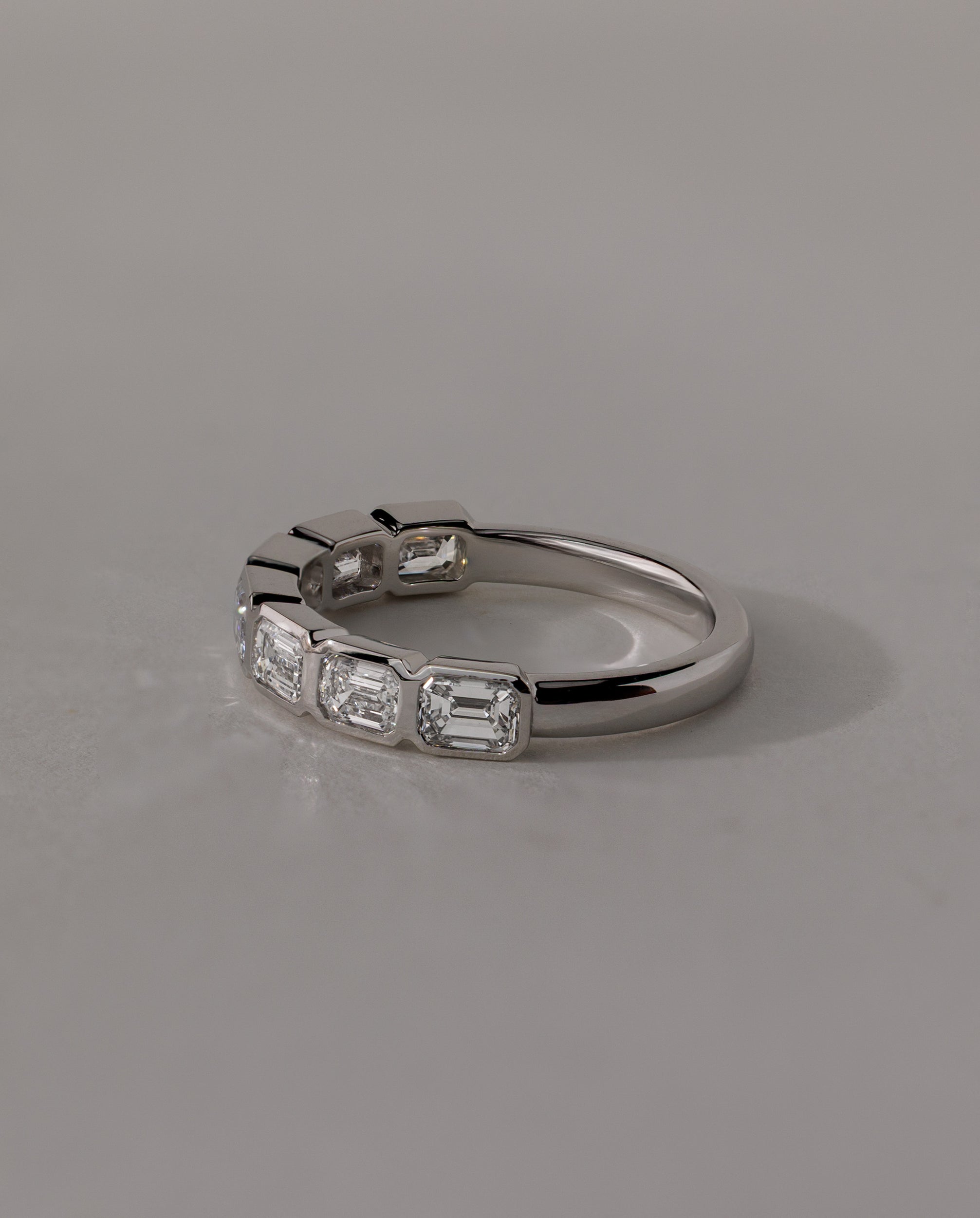 1.05 TCW emerald cut moissanite wedding band with bezel setting – sleek and sophisticated gold ring featuring step-cut stones, perfect for modern bridal or stacking style.