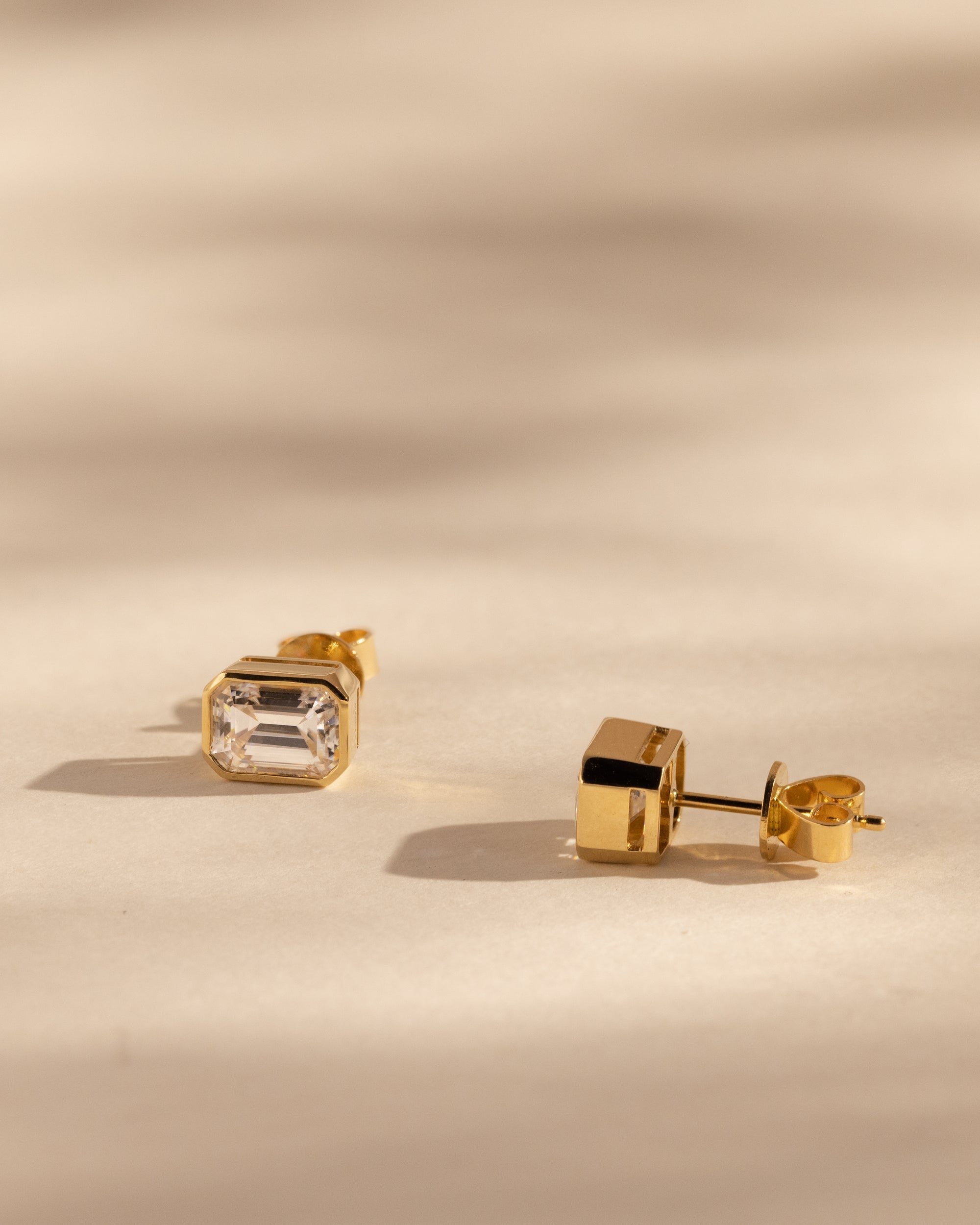 2.00 TCW emerald cut moissanite bezel set earrings – sleek and sophisticated gold studs featuring step-cut stones, perfect for modern bridal or everyday luxury.