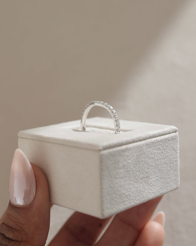 0.25 TCW round cut moissanite curved wedding band – delicate contour design crafted in polished gold, perfect for stacking with engagement rings.