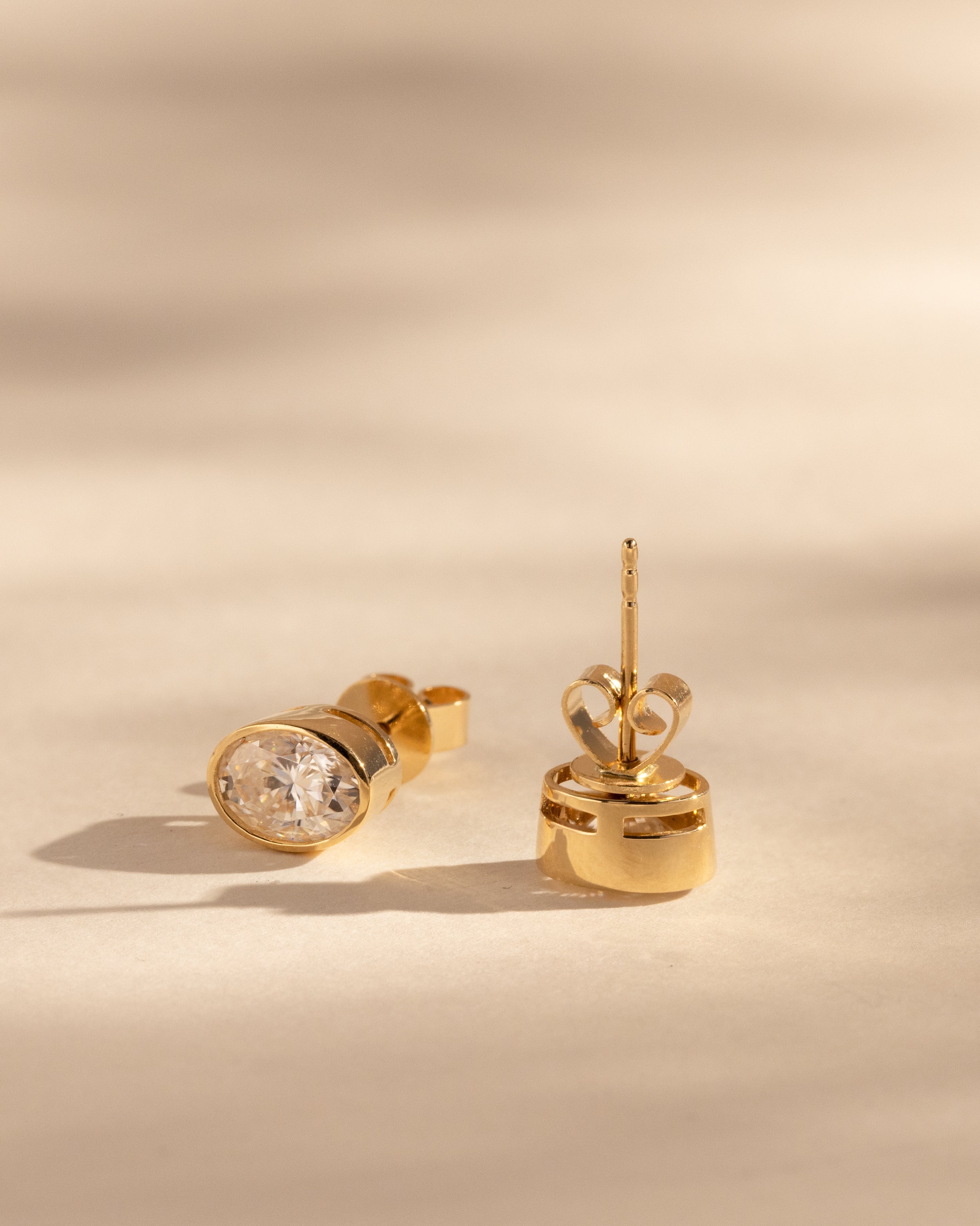 1.00 CT oval cut moissanite bezel set earrings – sleek and elegant gold studs with a modern, secure setting, perfect for everyday wear or special occasions.