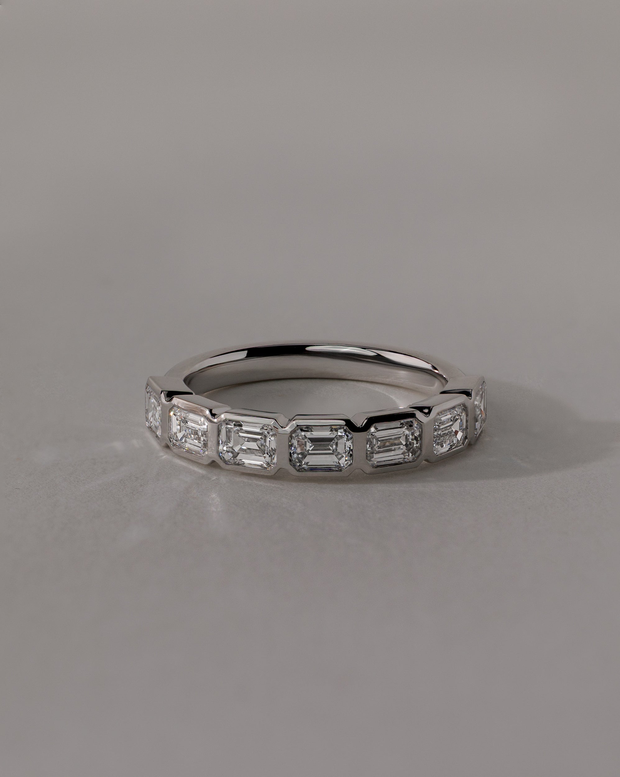 1.05 TCW emerald cut moissanite wedding band with bezel setting – sleek and sophisticated gold ring featuring step-cut stones, perfect for modern bridal or stacking style.