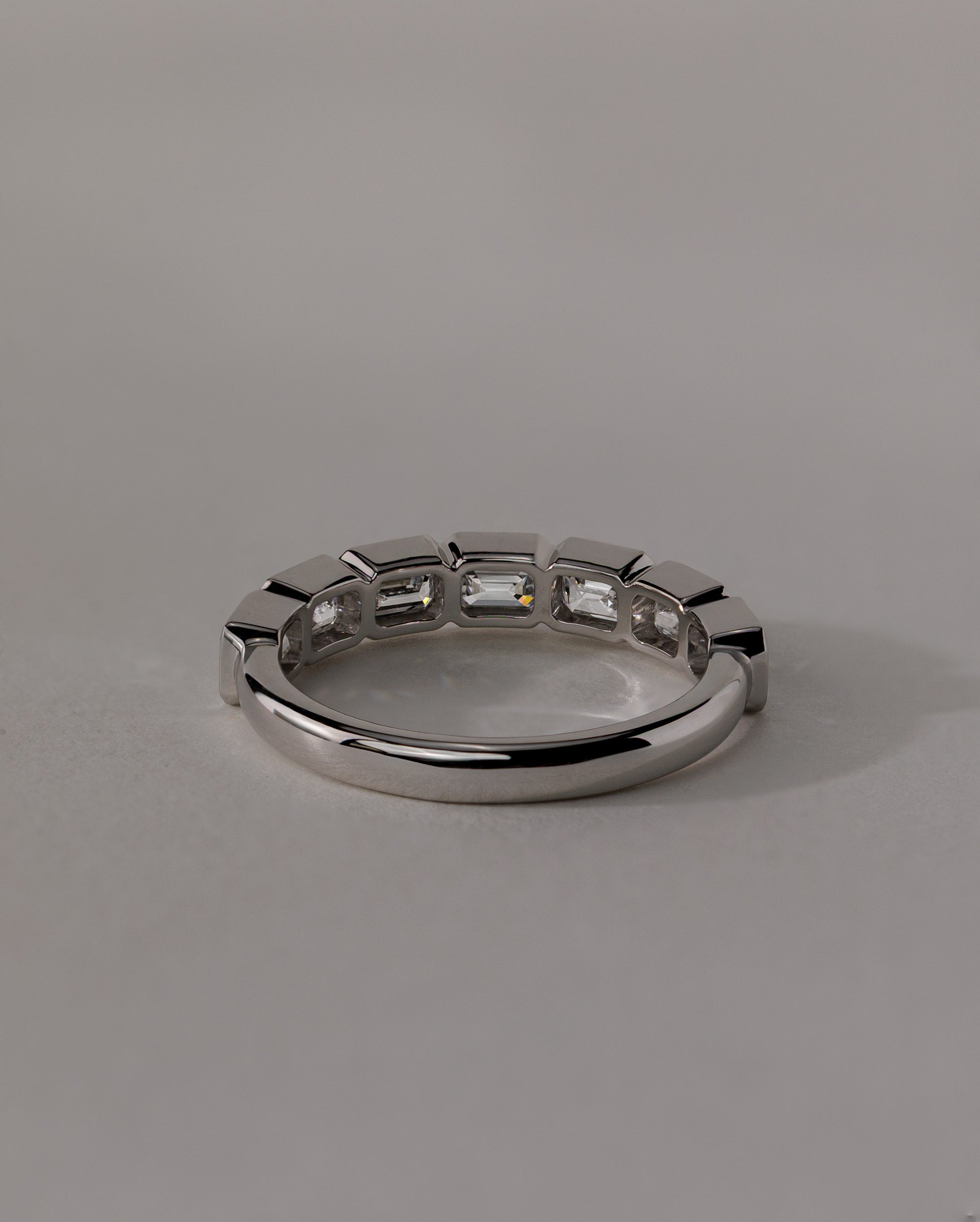 1.05 TCW emerald cut moissanite wedding band with bezel setting – sleek and sophisticated gold ring featuring step-cut stones, perfect for modern bridal or stacking style.